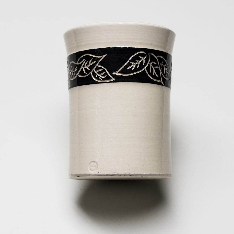 Bote de loza blanca con engobe negro y decoración incisa